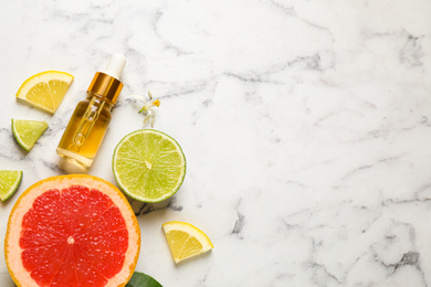 Photo of Flat lay composition with bottle of citrus essential oil on white marble background. Space for text