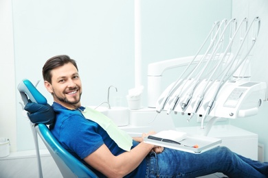 Happy man having dentist's appointment in modern office