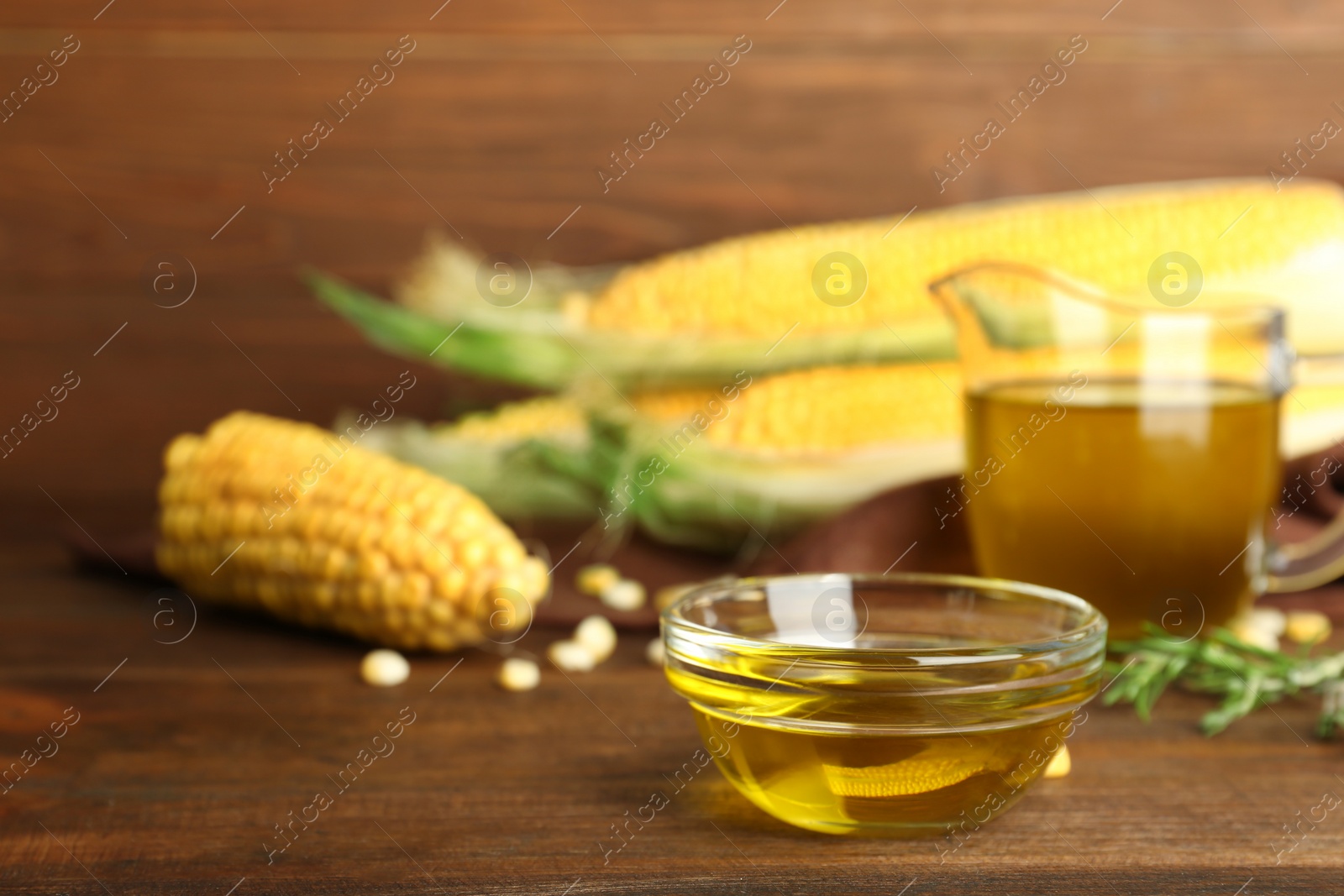 Photo of Bowl with fresh corn oil on wooden table