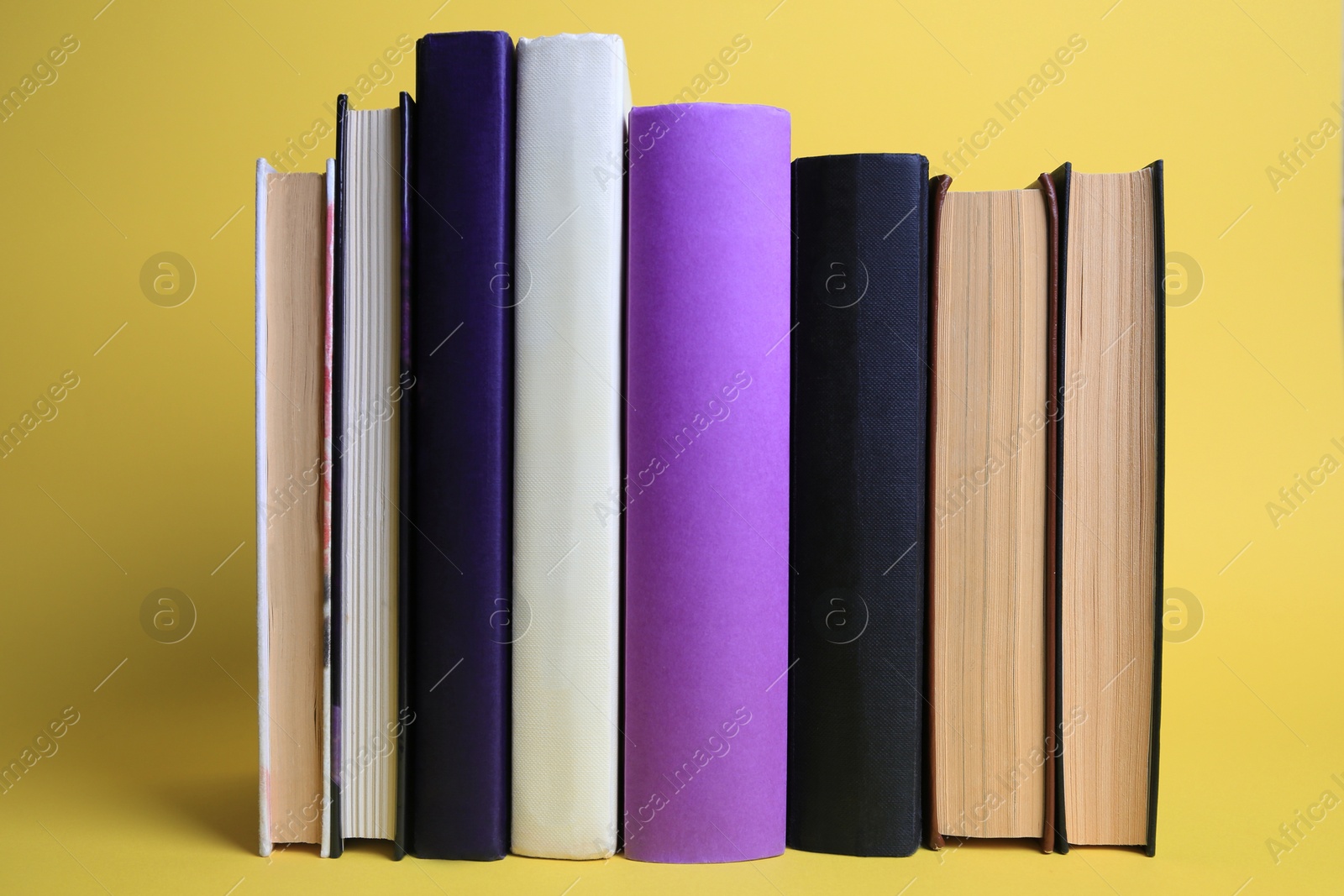 Photo of Collection of hardcover books on yellow background