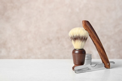 Photo of Shaving accessories on table against color background with space for text