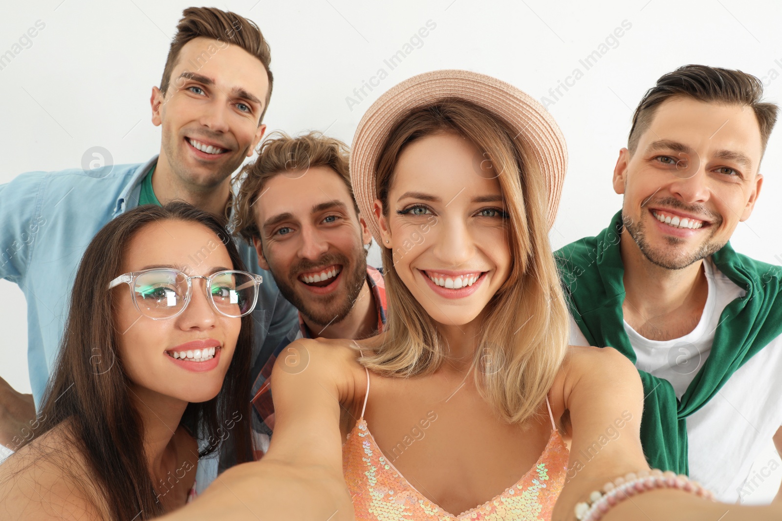 Photo of Group of happy young people taking selfie on white background