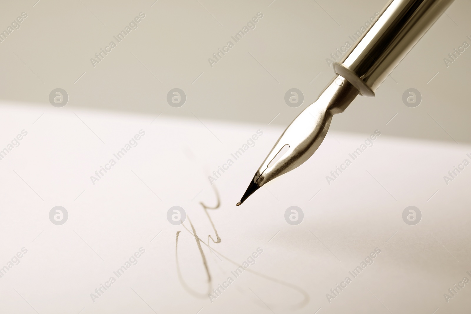 Photo of Signing on sheet of paper with fountain pen against light grey background, closeup. Space for text