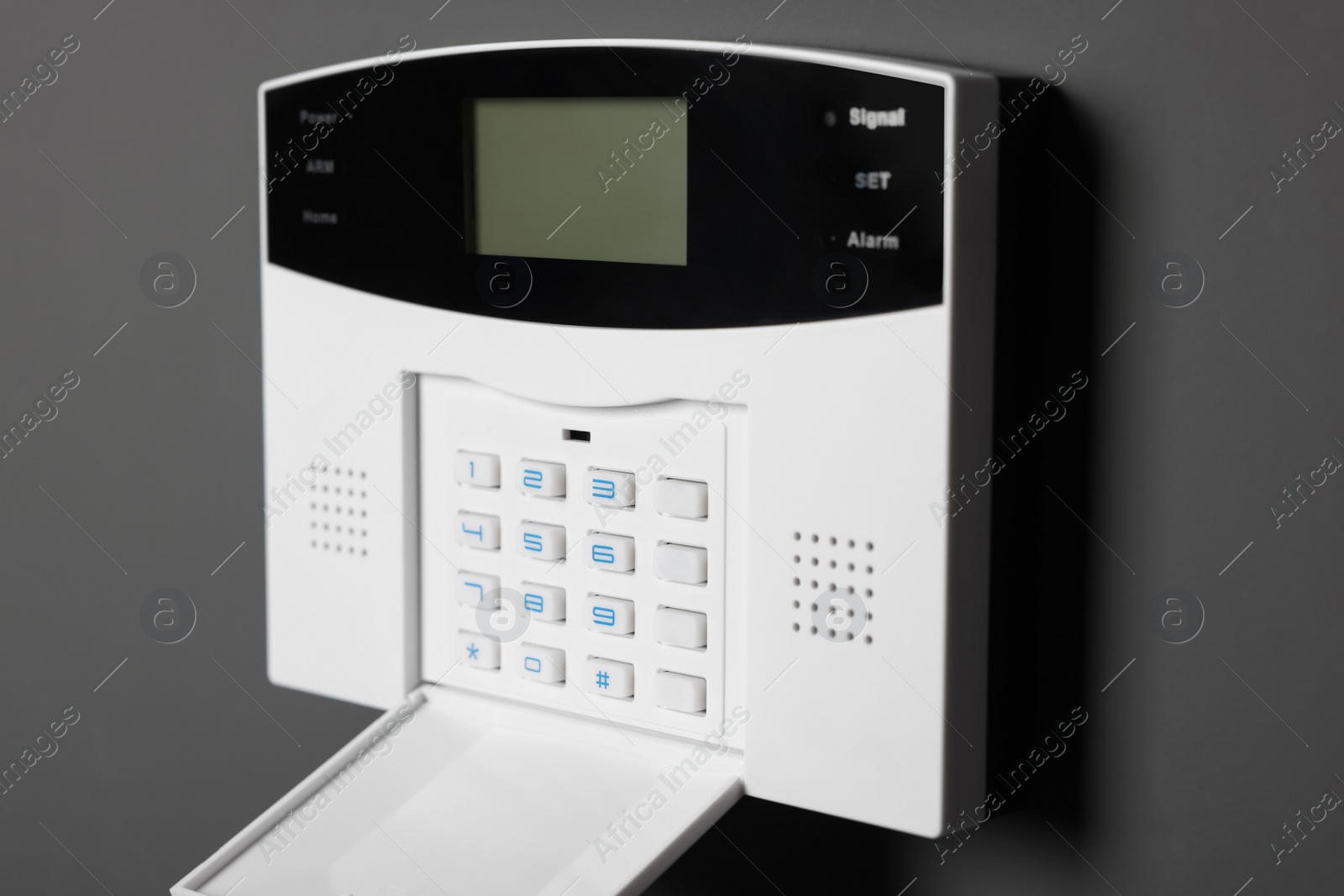 Photo of Home security alarm system on gray wall, closeup