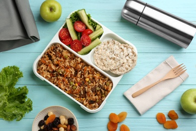 Flat lay composition with thermos and lunch box on turquoise wooden background