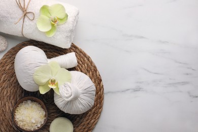 Flat lay composition with spa products and beautiful flowers on white marble table. Space for text