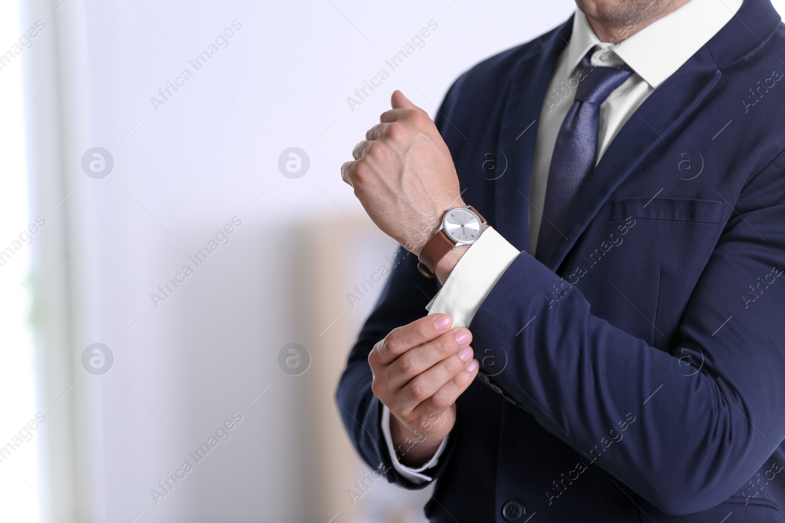 Photo of Businessman with wristwatch on blurred background, Time concept