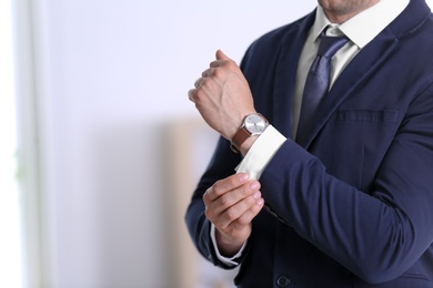 Photo of Businessman with wristwatch on blurred background, Time concept