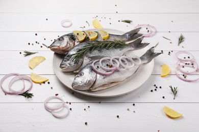 Composition with raw dorado fish and spices on white wooden table