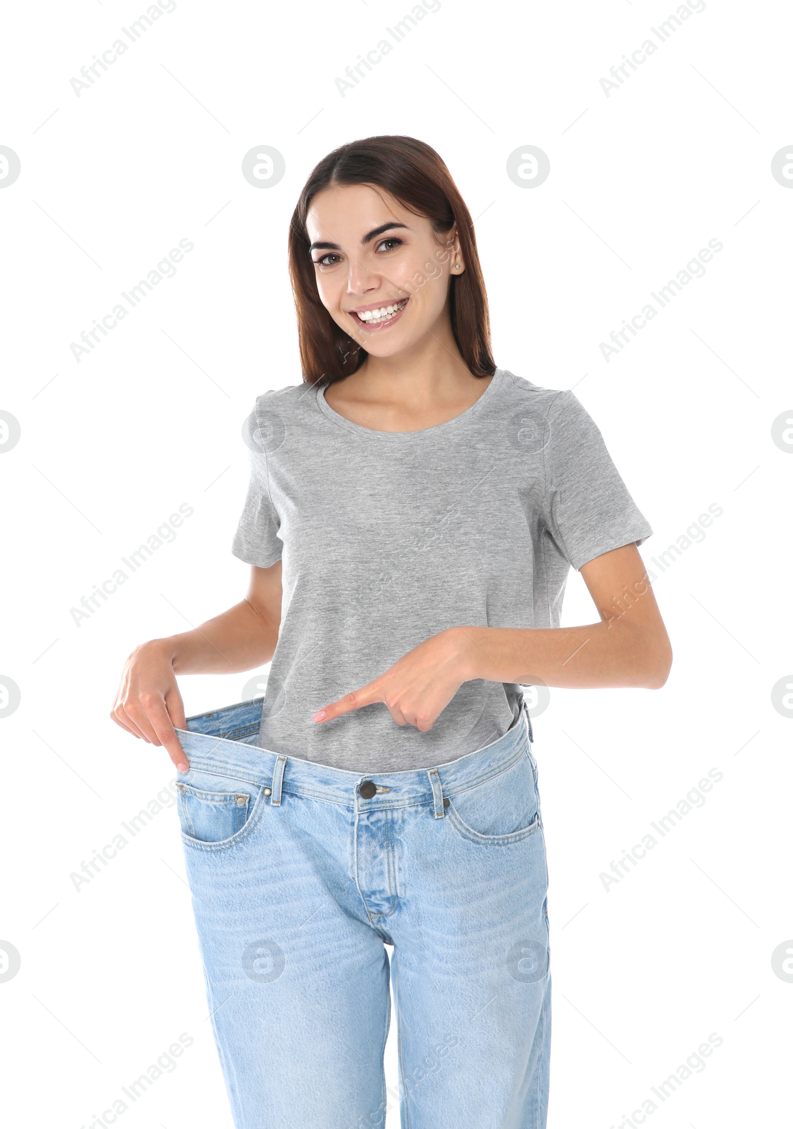 Photo of Slim woman in oversized jeans on white background. Weight loss