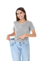 Photo of Slim woman in oversized jeans on white background. Weight loss