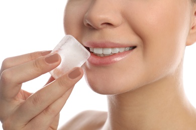 Young woman with ice cube on white background, closeup. Skin care