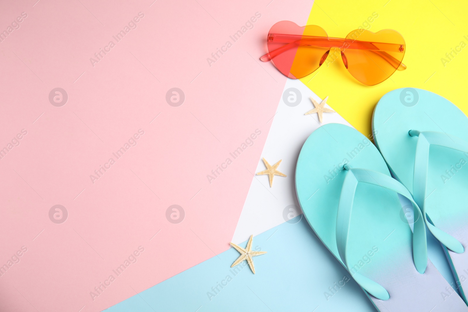 Photo of Flat lay composition with flip flops and sunglasses on color background. Space for text