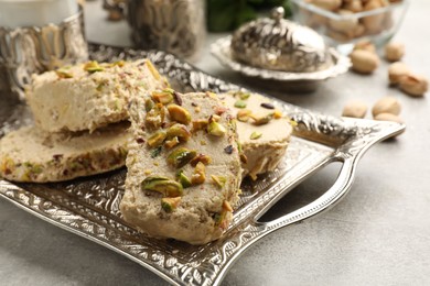 Photo of Tasty pistachio halva on light grey table, closeup