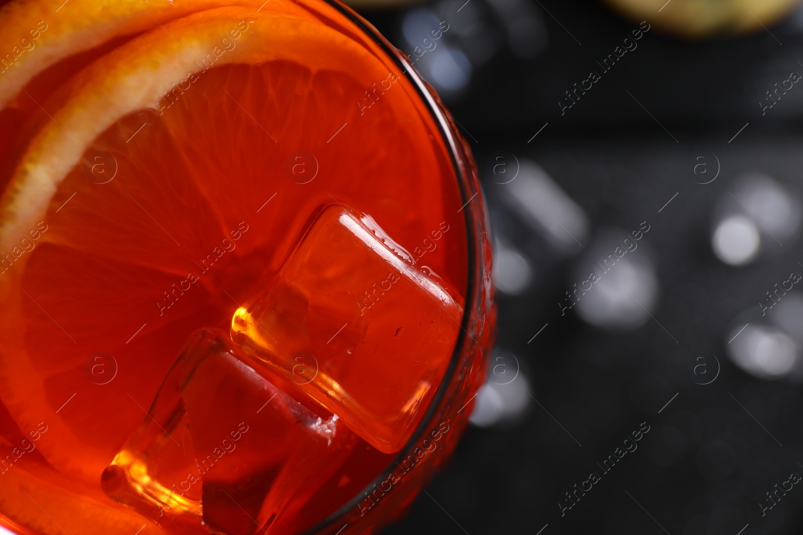 Photo of Tasty Aperol spritz cocktail with ice cubes in glass, top view. Space for text