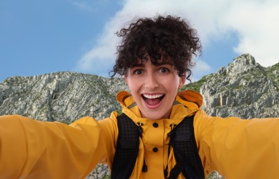 Image of Beautiful young woman taking selfie in mountains