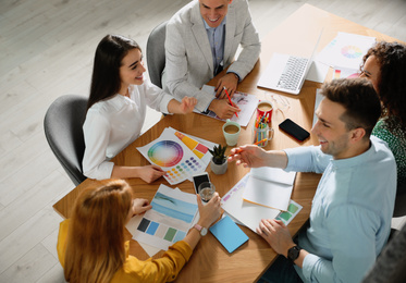 Team of professional designers working together at table in office