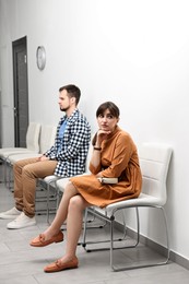 Woman and man waiting for appointment indoors