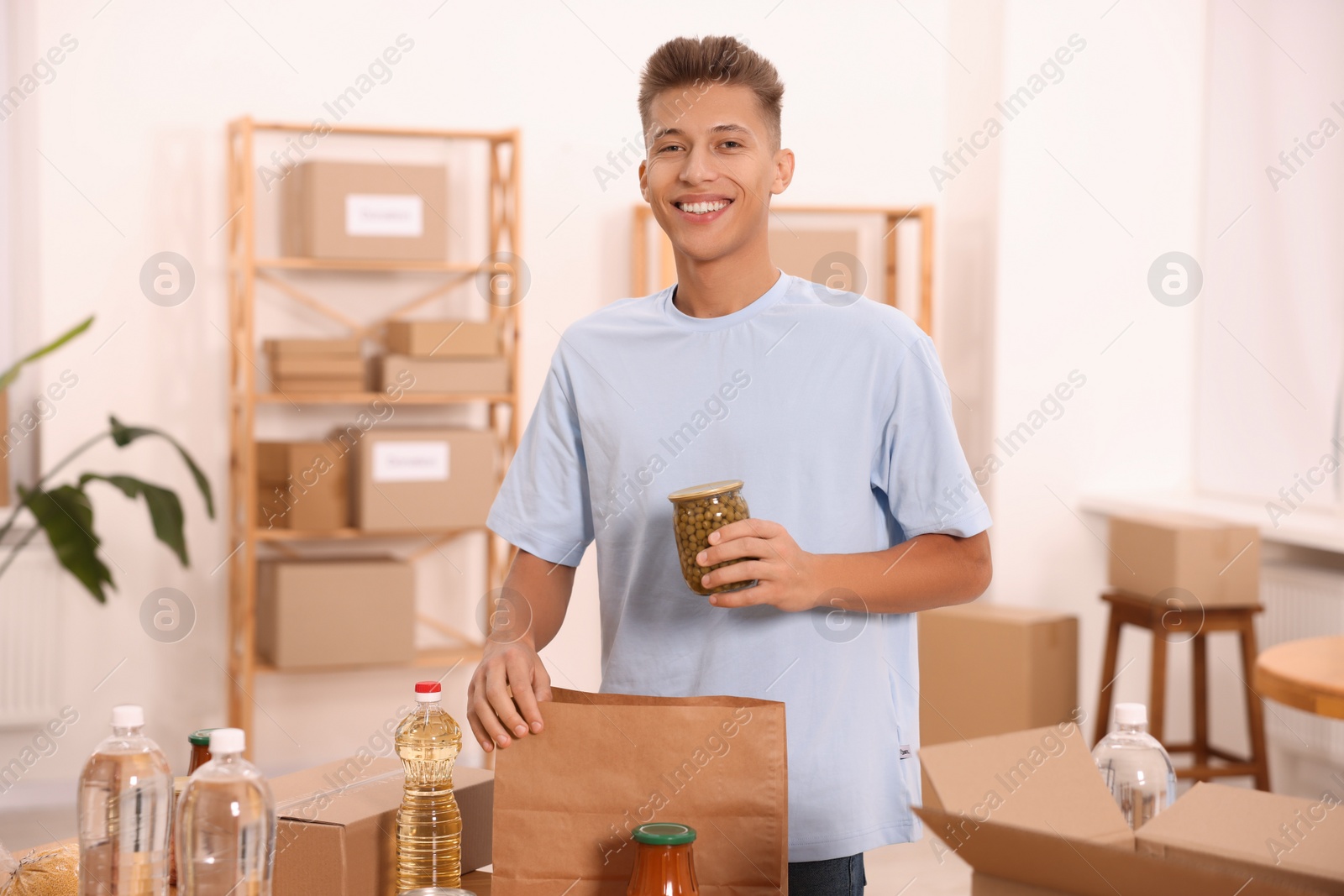 Photo of Volunteer packing food products at table in warehouse