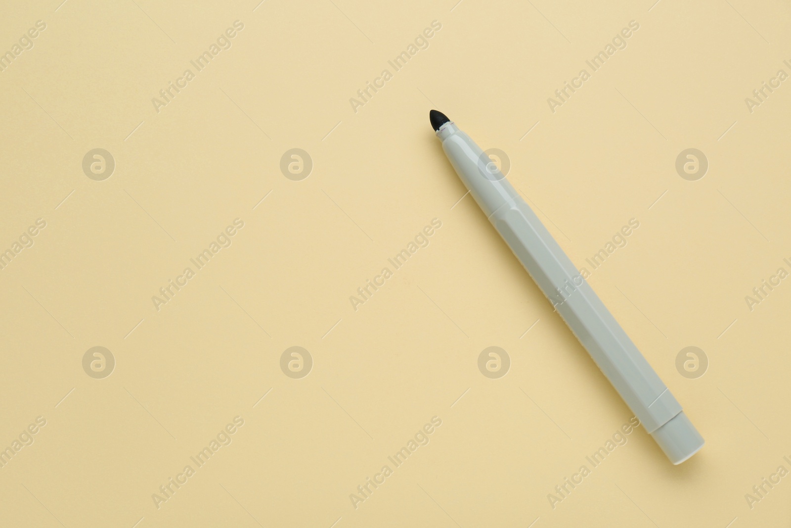 Photo of Grey marker on beige background, top view. Space for text