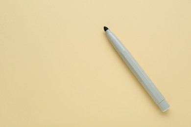 Photo of Grey marker on beige background, top view. Space for text