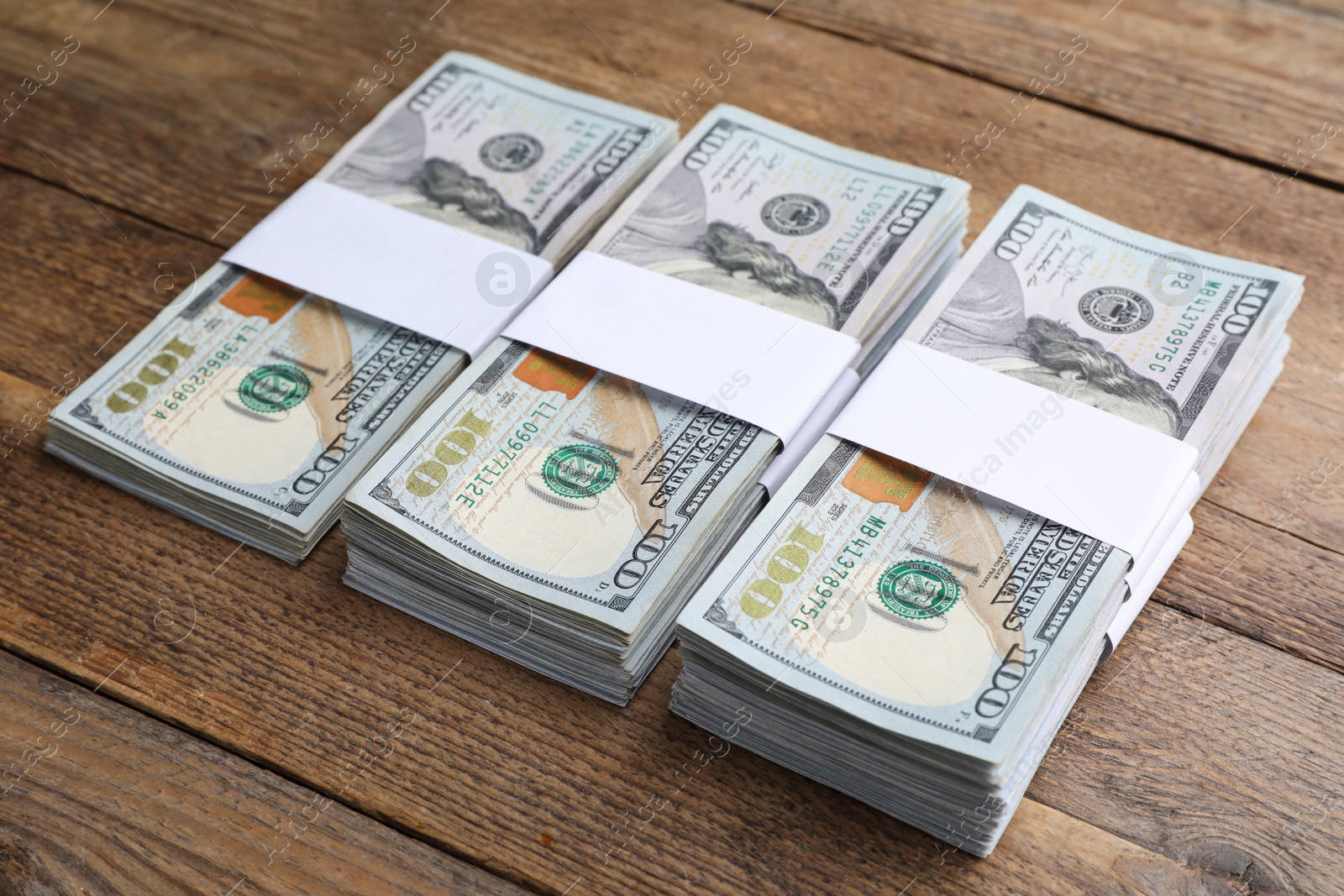 Photo of Many dollar banknotes on wooden table. American national currency