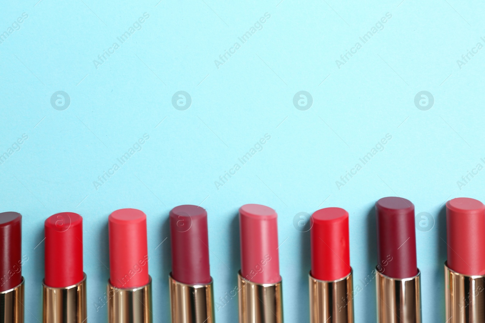 Photo of Flat lay composition with different stylish lipsticks on color background, space for text