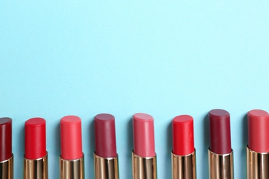 Photo of Flat lay composition with different stylish lipsticks on color background, space for text