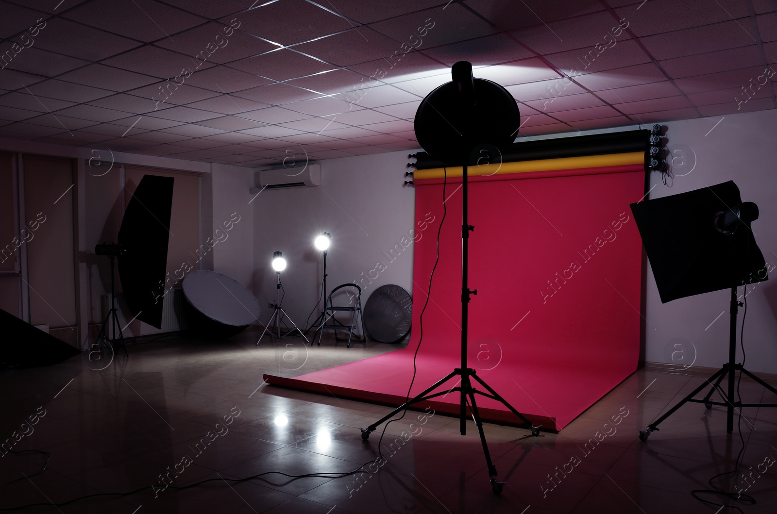 Photo of Interior of modern photo studio with professional lighting equipment