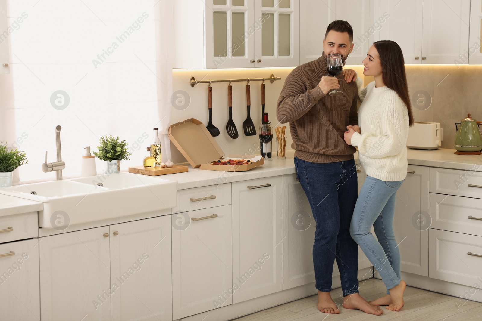 Photo of Happy young couple spending time together in kitchen. Space for text