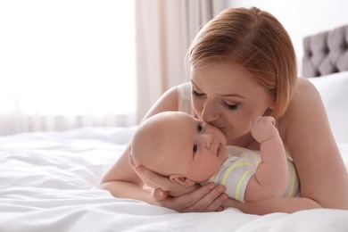 Mother with her little baby on bed at home