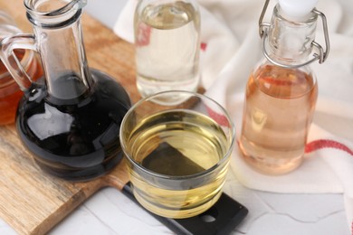 Different types of vinegar on white table