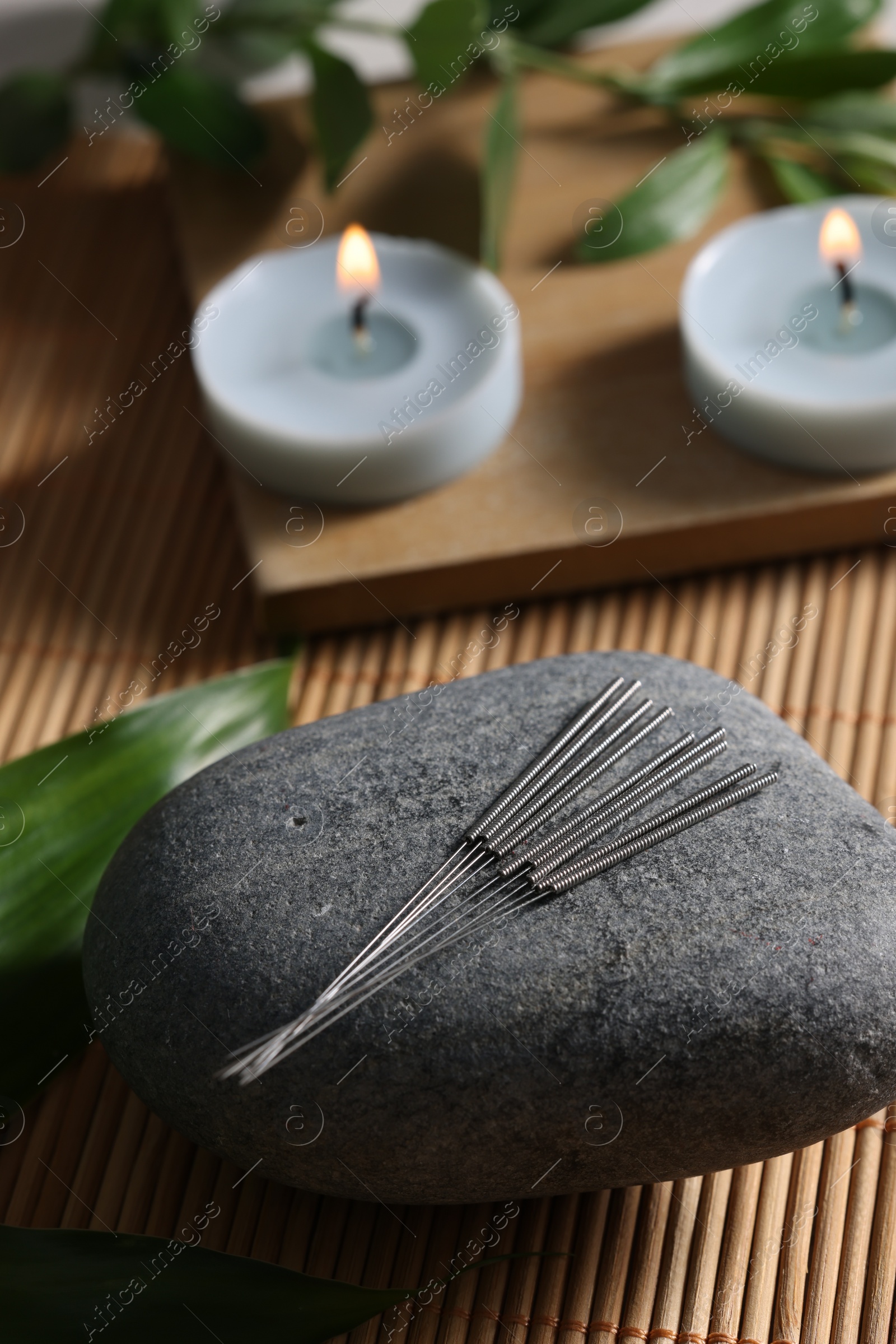 Photo of Stone with acupuncture needles on bamboo mat