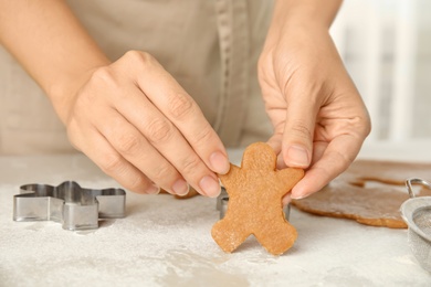 Woman holding Christmas cookie at light table, closeup