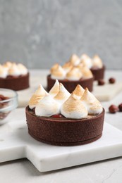 Photo of Delicious salted caramel chocolate tart with meringue on light grey table