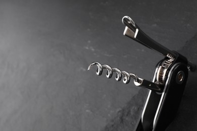 Photo of One corkscrew (sommelier knife) on grey table, closeup. Space for text