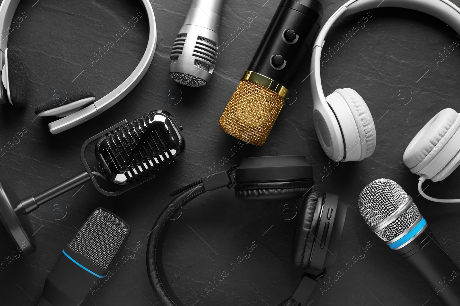 Photo of Different microphones and headphones on grey textured background, flat lay. Sound recording and reinforcement