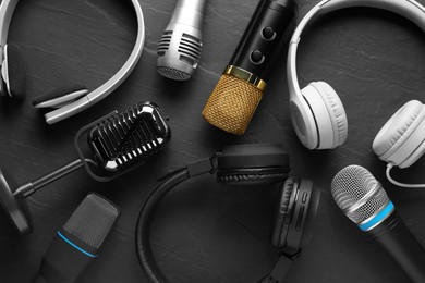Photo of Different microphones and headphones on grey textured background, flat lay. Sound recording and reinforcement
