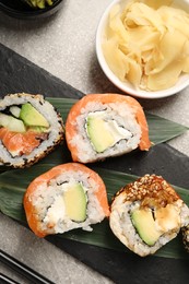 Delicious sushi rolls and ginger on light grey table, flat lay