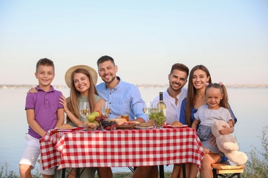 Happy families with little children at picnic table outdoors