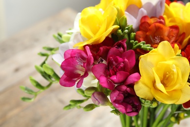 Photo of Beautiful spring freesia flowers on blurred background, closeup