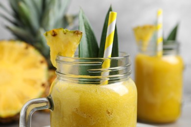 Tasty pineapple smoothie on blurred background, closeup