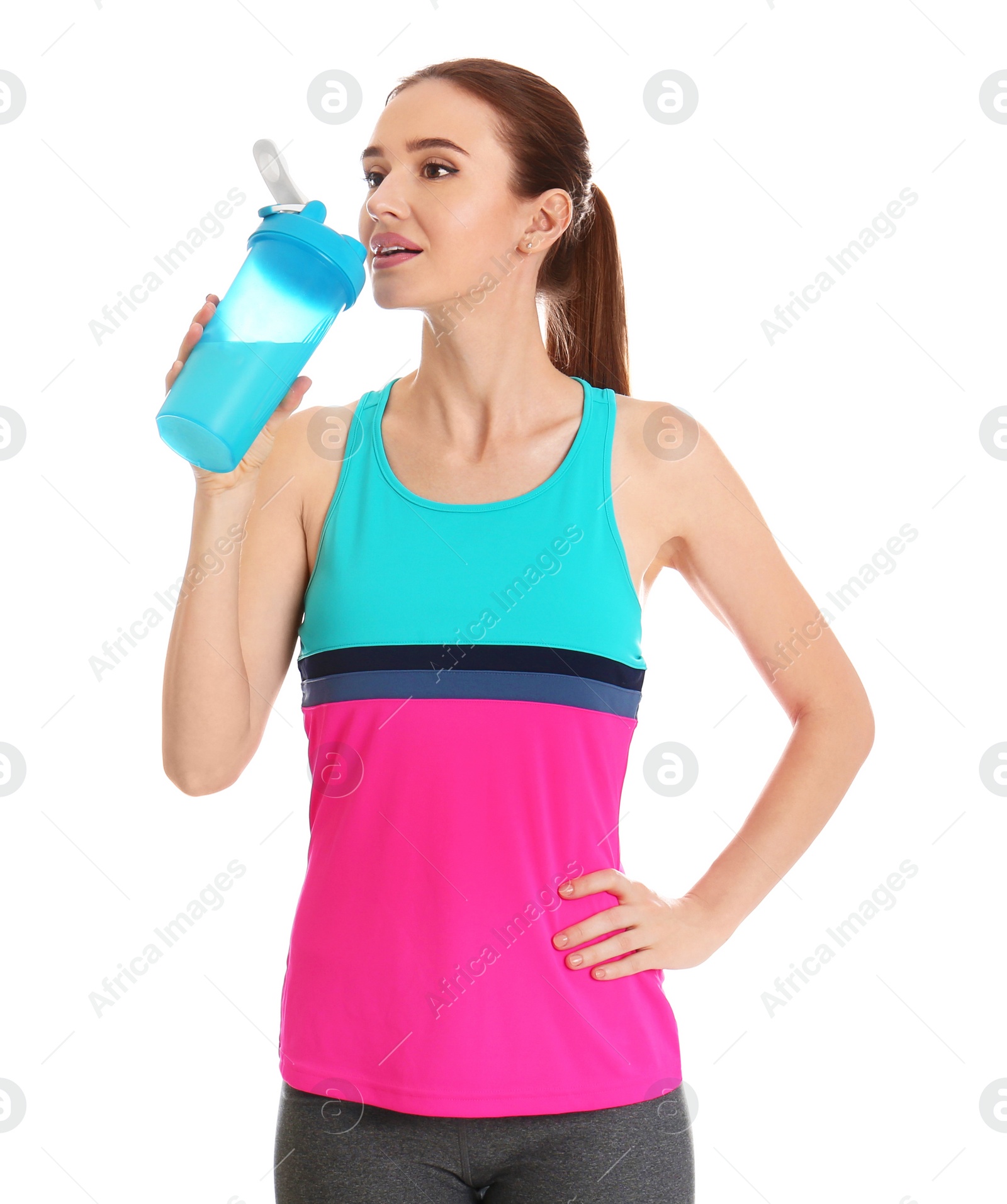 Photo of Athletic young woman drinking protein shake on white background