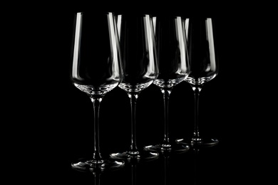 Photo of Set of empty wine glasses on black background