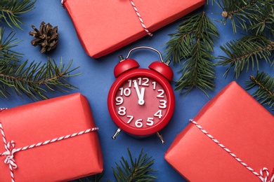 Flat lay composition with Christmas gifts and alarm clock on blue background. Boxing day