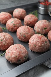 Photo of Many fresh raw meatballs in baking dish, closeup