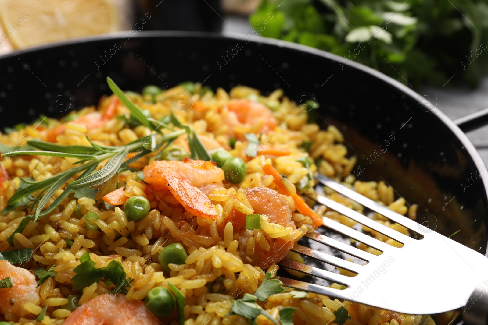 Photo of Tasty rice with shrimps and vegetables in frying pan, closeup