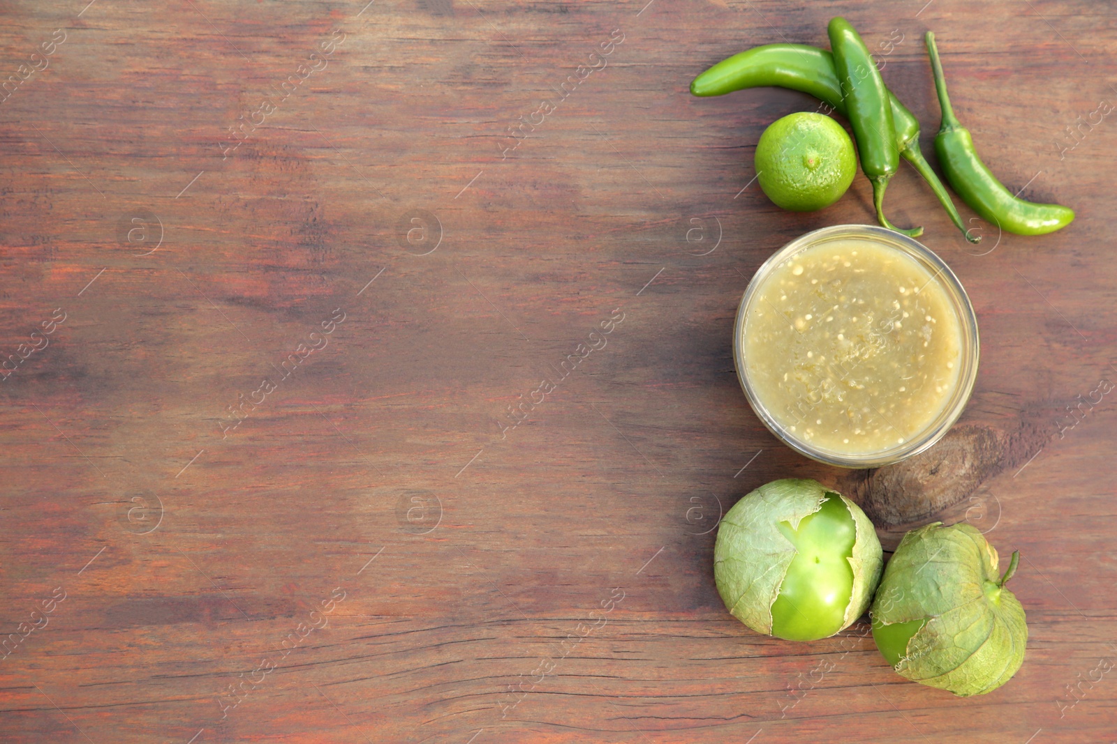 Photo of Tasty salsa sauce and ingredients on wooden table, flat lay. Space for text