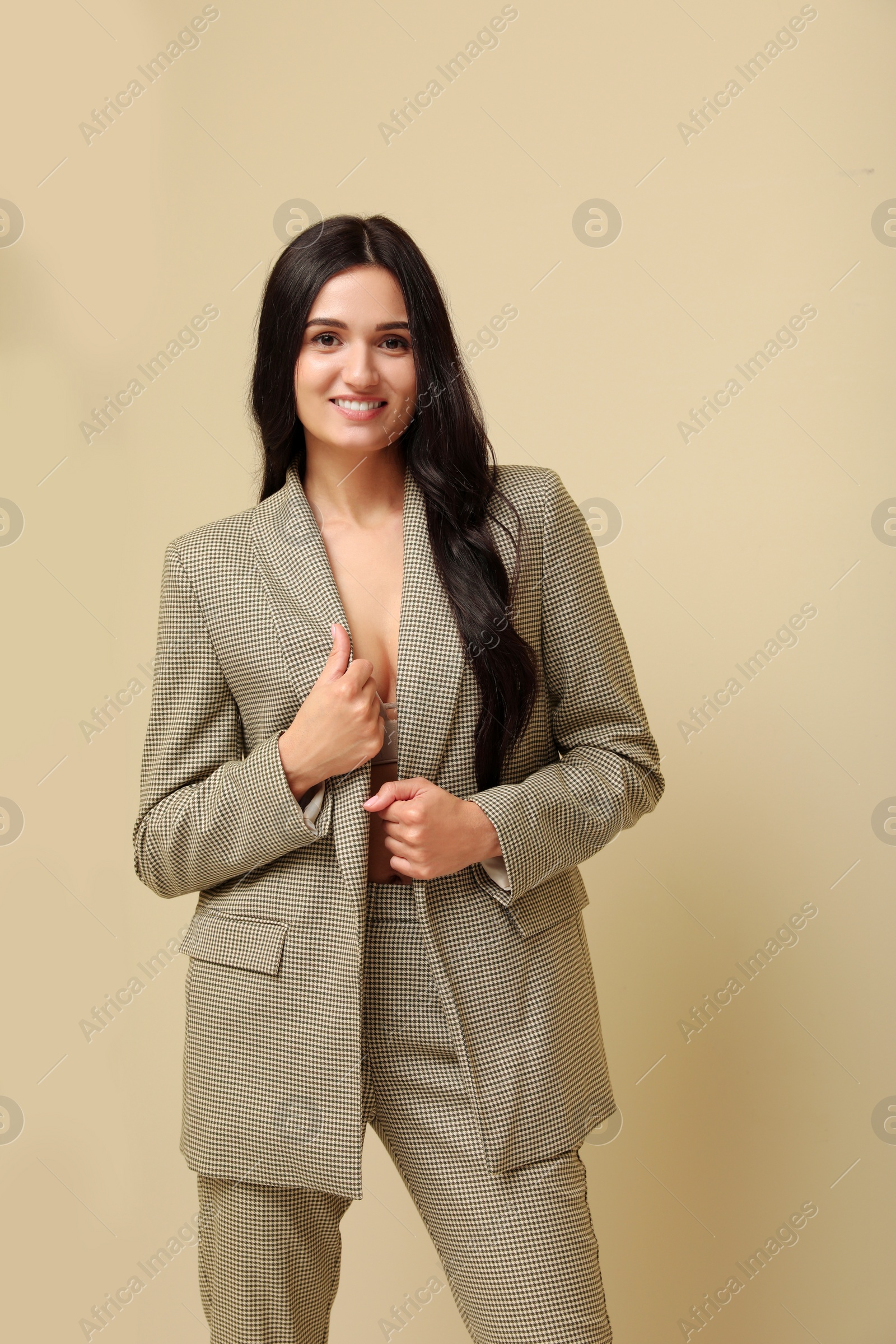 Photo of Beautiful woman in formal suit on beige background