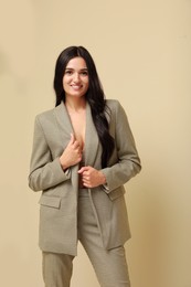 Beautiful woman in formal suit on beige background